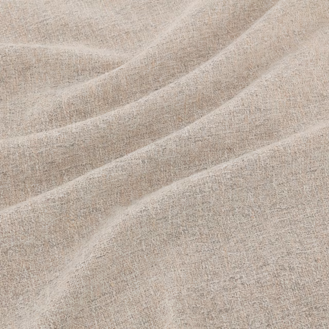 Pale greige taupe woven fabric with flecked texture forming soft diagonal folds