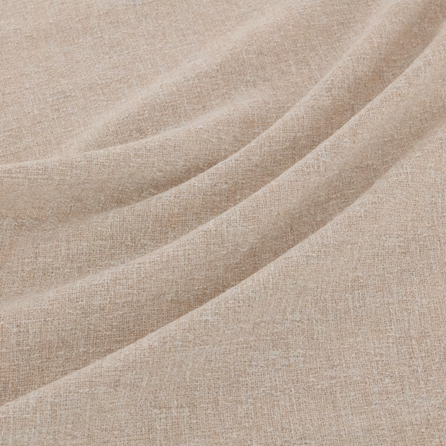 Warm beige woven fabric draped in broad folds, showing subtle natural tonal variation