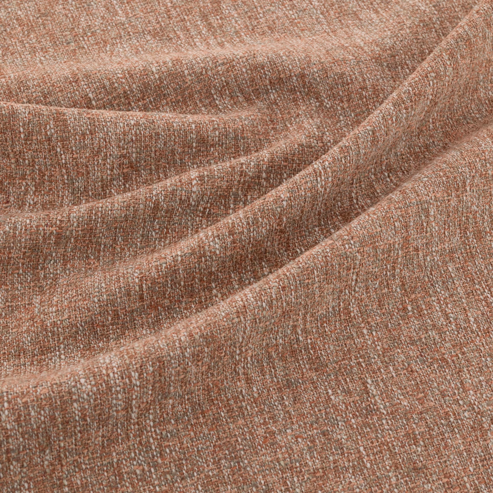 Close-up of warm terracotta woven fabric with pale flecks and softly folded texture