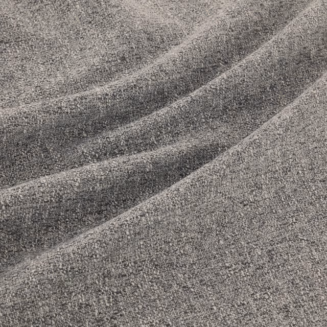 Close-up of charcoal-grey flecked weave falling into soft diagonal folds