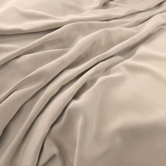 Warm oyster taupe velvet with creamy highlights and deep folds across its smooth surface