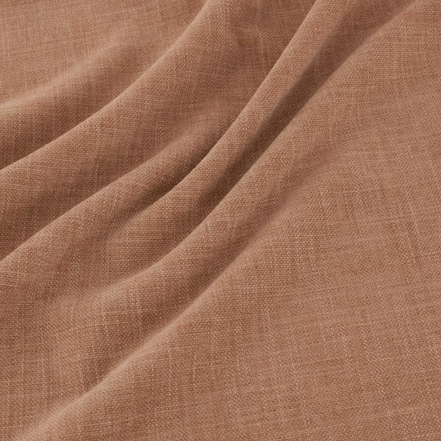 Warm kiln terracotta plain-weave fabric draped in soft, tactile folds