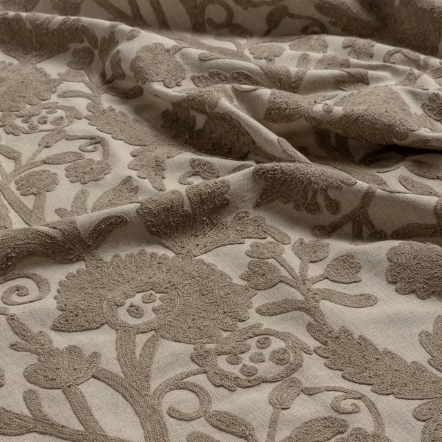Warm ivory fabric with raised taupe floral, paisley and scrolling motifs