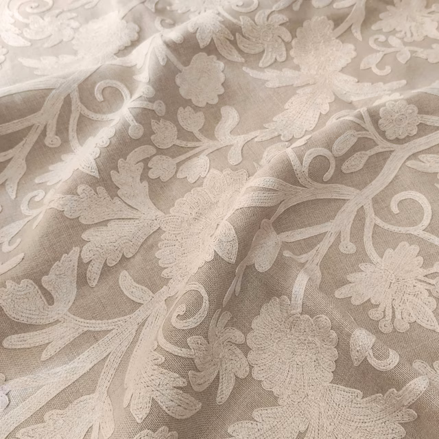 Warm parchment beige fabric with ivory scrolling flowers, leaves and fine woven texture