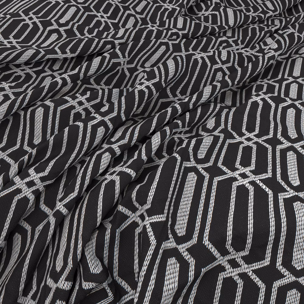 Charcoal and ivory woven fabric with interlocking angular motifs in gathered folds