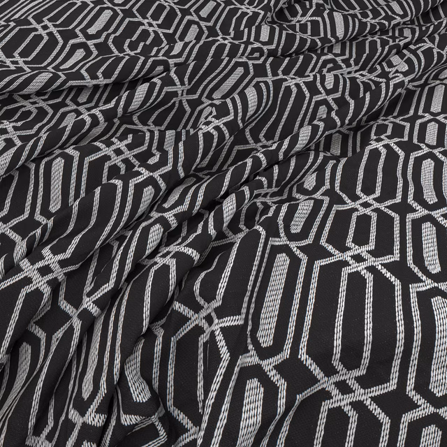 Charcoal and ivory woven fabric with interlocking angular motifs in gathered folds