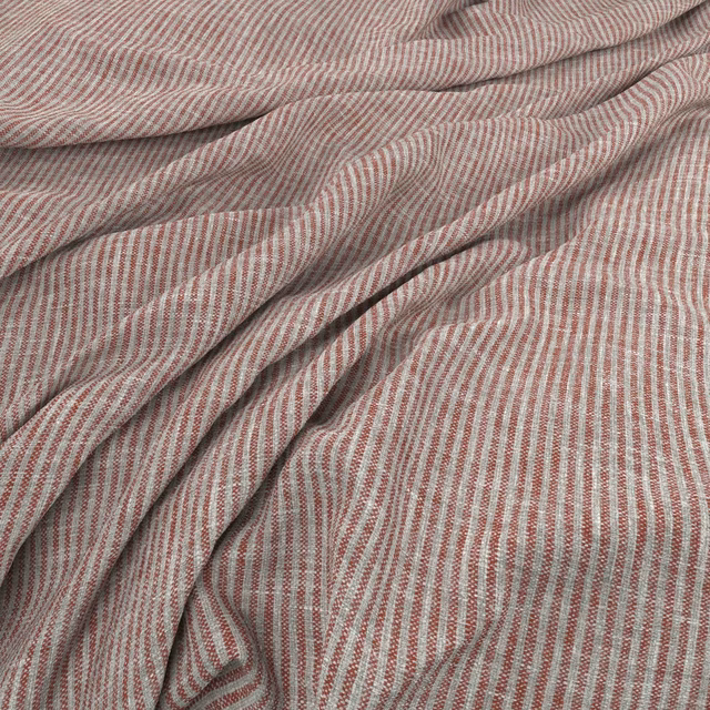 Muted terracotta and pale neutral fine stripes in a softly folded woven cloth