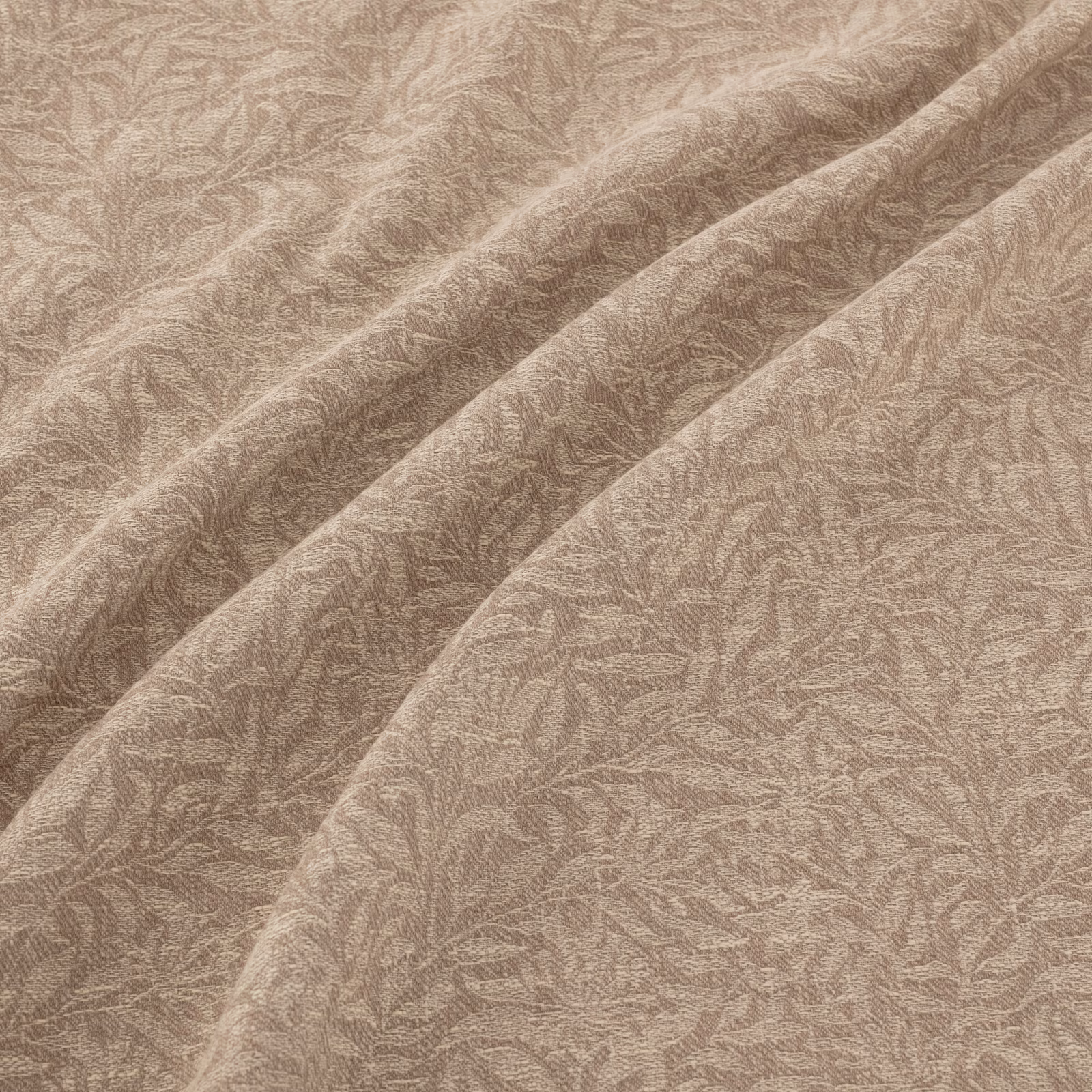 Warm natural taupe fabric with fine leafy filigree texture draped into soft folds
