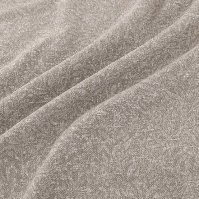 Soft silver-grey fabric with a fine leafy filigree weave across diagonal folds