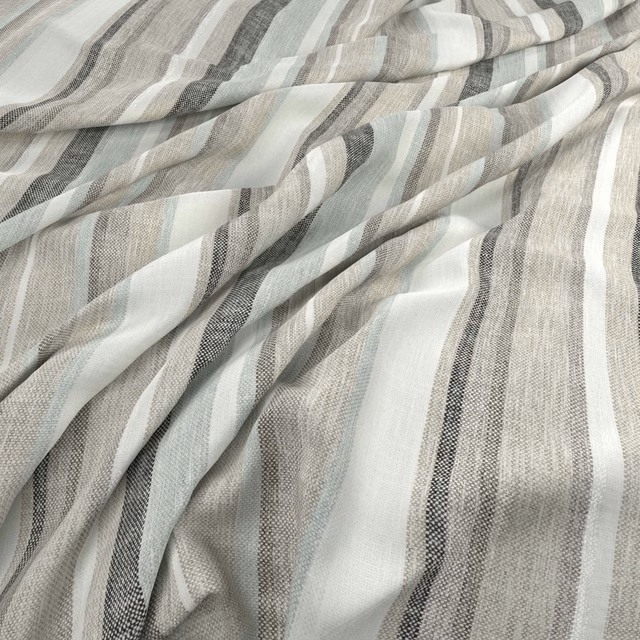 Misty blue-grey and ivory striped fabric with fine woven texture in soft folds