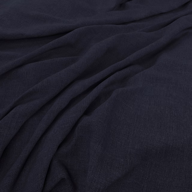 Dark ink navy plain-weave fabric gathered into softly shadowed folds