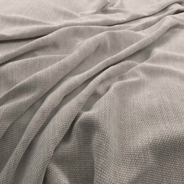 Pale greige woven fabric with fine granular texture gathered into soft folds