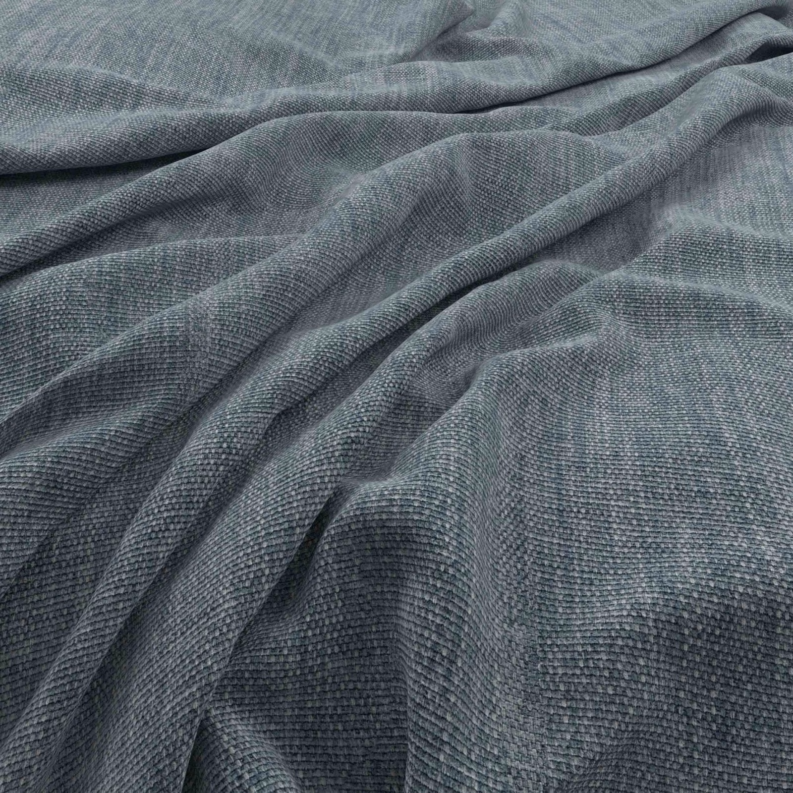 Close-up of muted denim-blue woven fabric with fine texture and deep draped folds