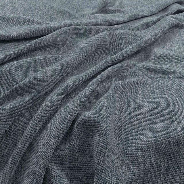 Close-up of muted denim-blue woven fabric with fine texture and deep draped folds