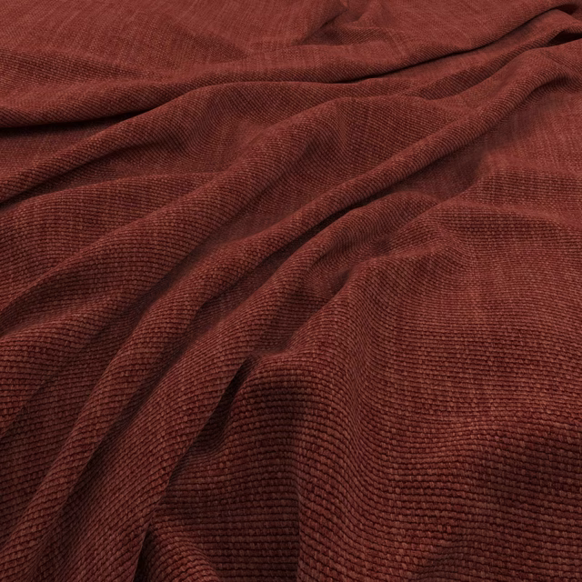 Deep oxblood-red textile with fine raised ribs folding into soft shadowed drapes