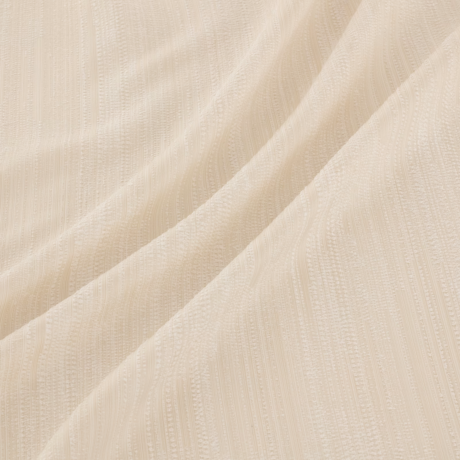 Warm ivory fabric with fine vertical woven texture in soft diagonal folds