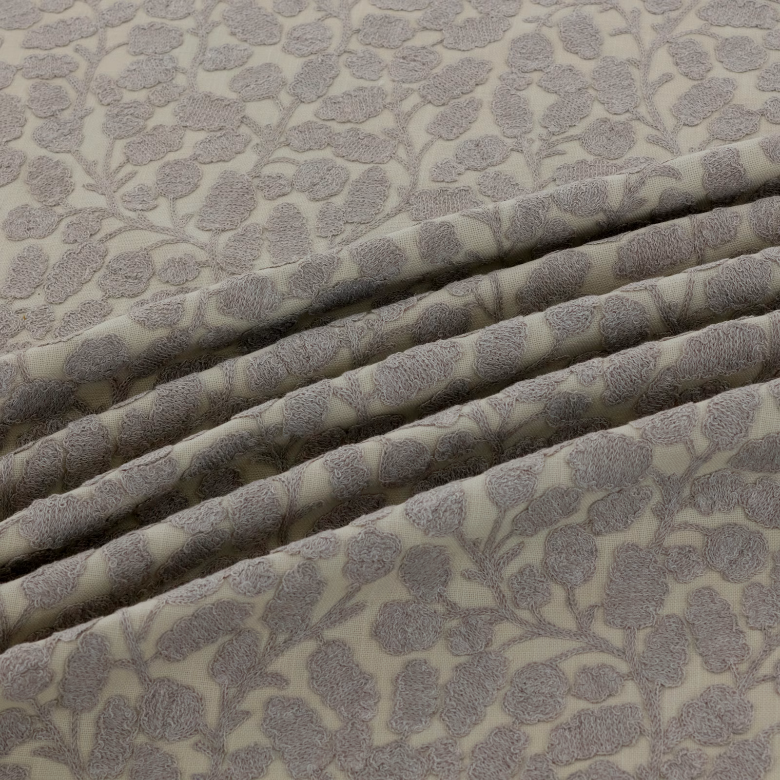 Warm greige floral fabric with raised grey blossoms and branching stems