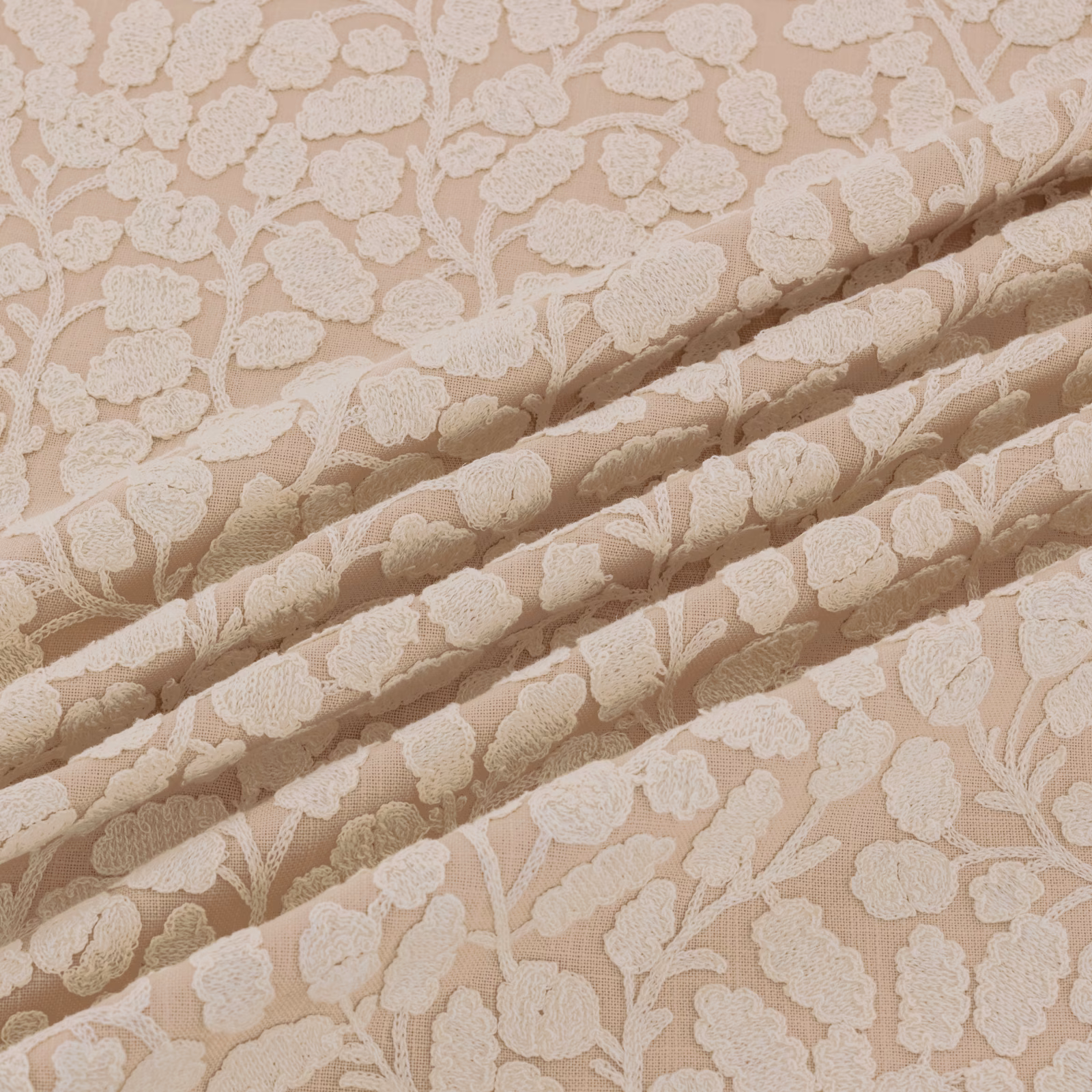 Warm shell-beige floral fabric with raised ivory blossoms and branching stems