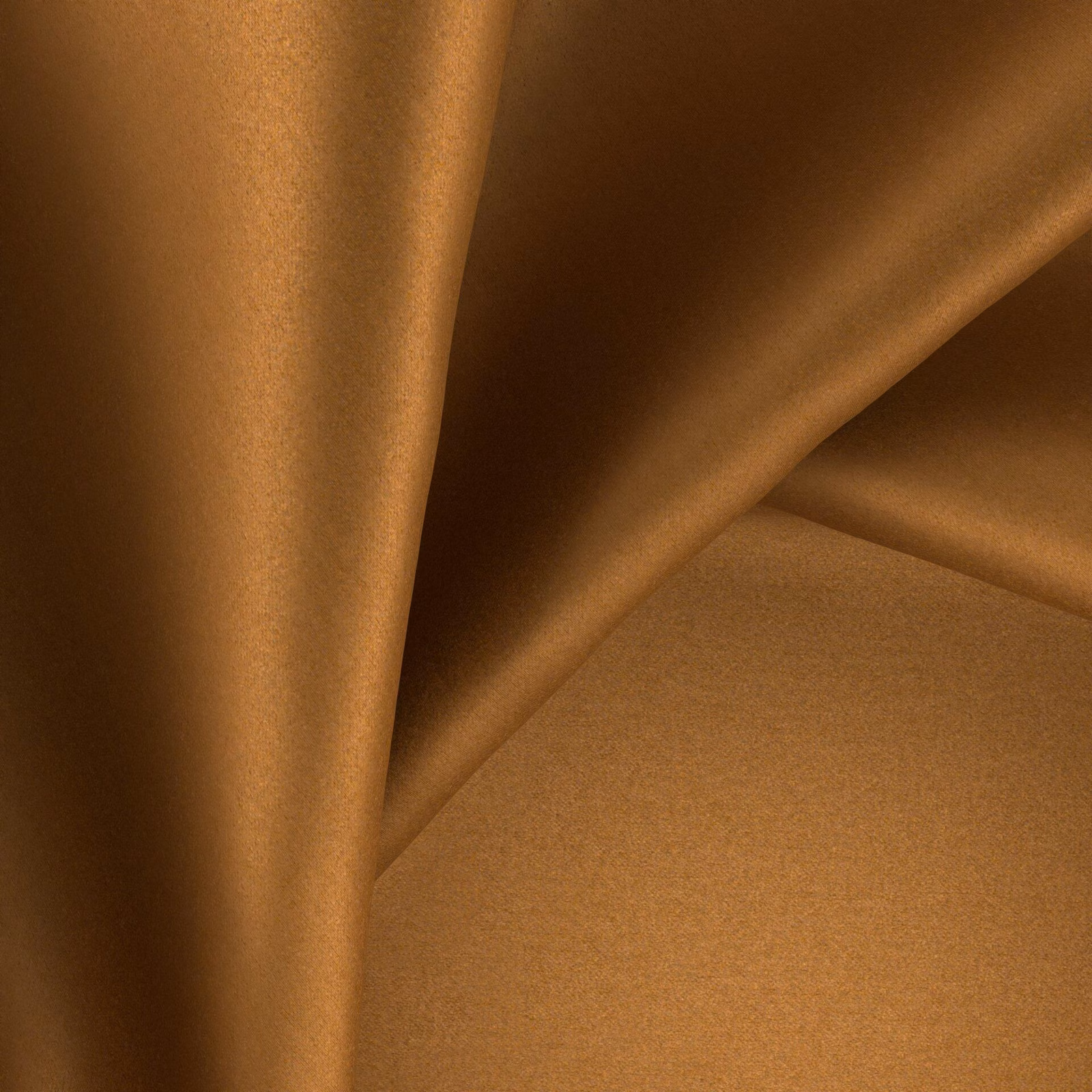 Warm amber-brown glossy fabric forming softly folded, light-catching drapes
