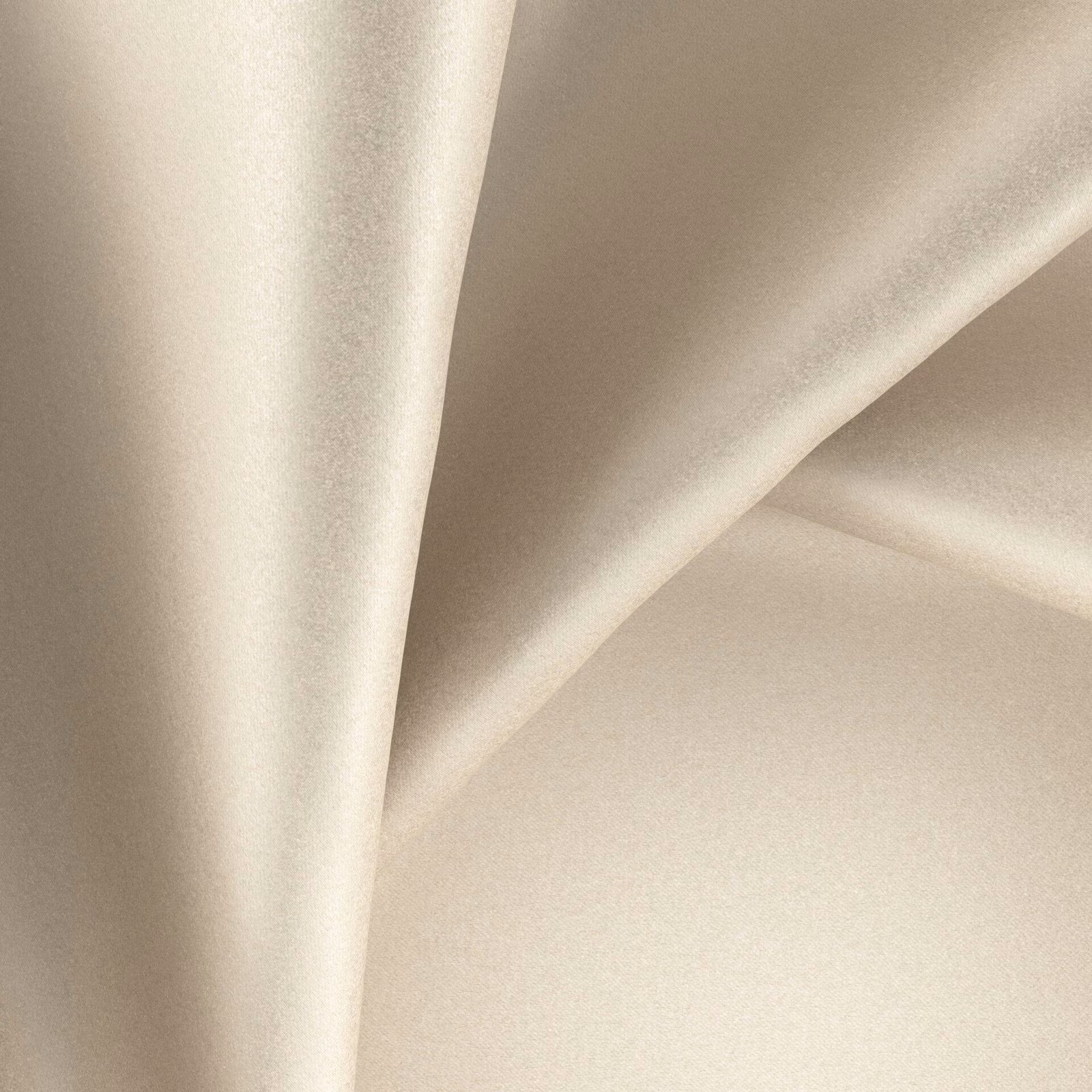 Warm buff-beige glossy fabric draped in soft, reflective folds