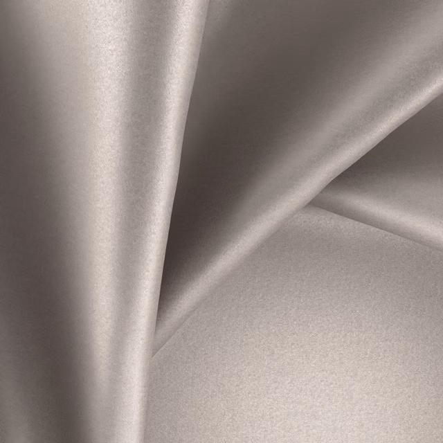 Pale warm greige plain fabric draped in smooth folds with a soft satin sheen