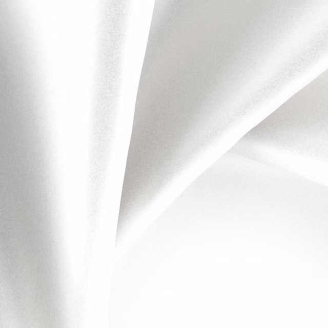 Pale pearl-white glossy fabric folded into fluid, reflective diagonal highlights
