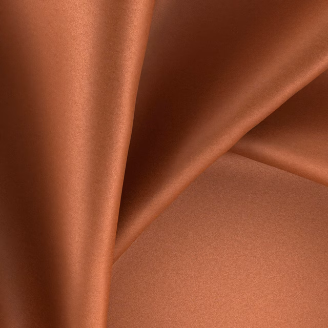 Burnished copper-terracotta fabric with glossy folds and smooth plain texture