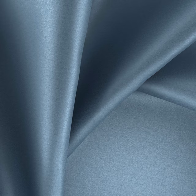 Cool slate blue-grey glossy fabric falling in softly reflective fluid folds