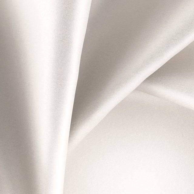 Pale ivory pearl textile falling in smooth, softly reflective draped folds