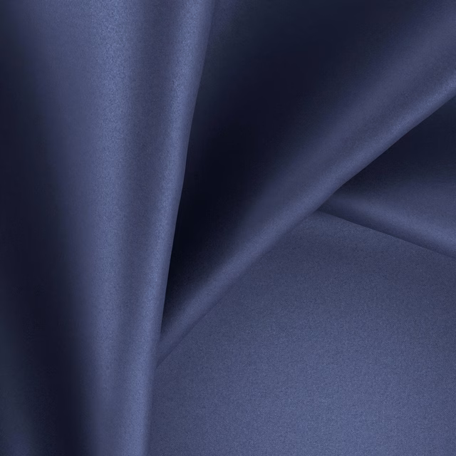 Deep sapphire-blue glossy fabric folded to show smooth texture and navy-shaded creases
