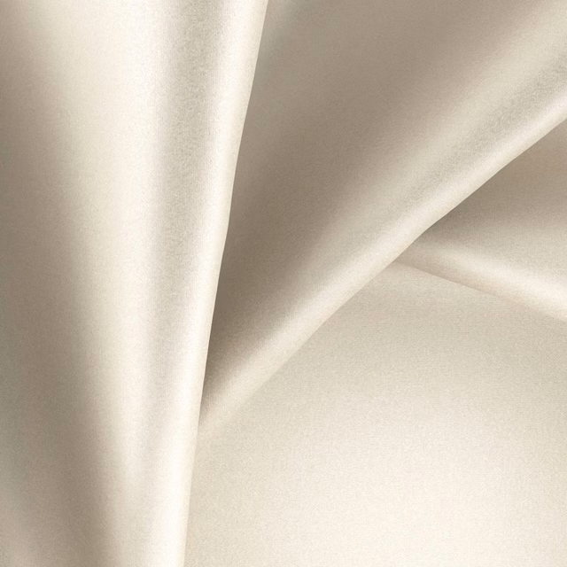 Warm ivory glossy textile with soft satin sheen and sculptural flowing folds