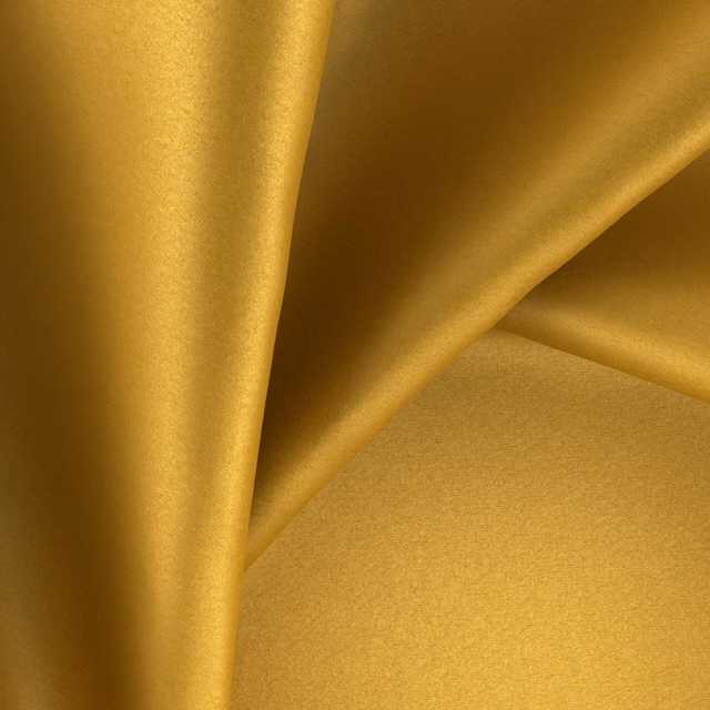 Warm golden topaz fabric with a smooth sheen folding into soft drapes
