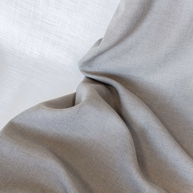 Soft ash-grey plain weave fabric gathered into folds with a fine textured surface