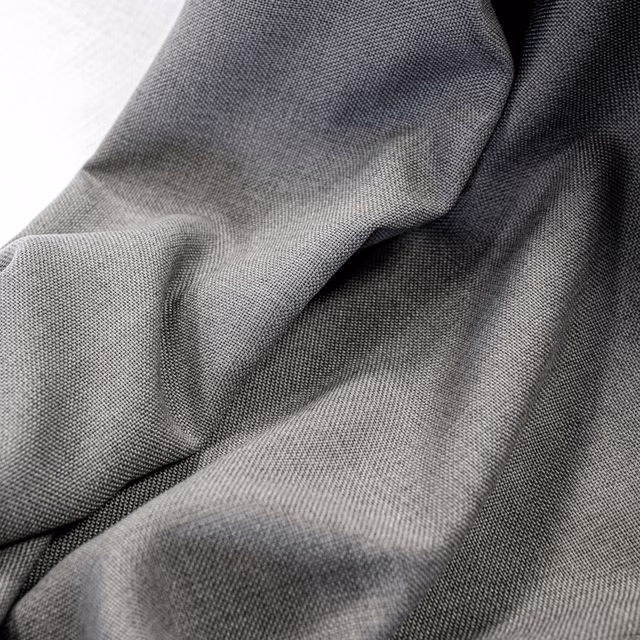 Cool charcoal-grey finely woven fabric draped into softly shadowed folds