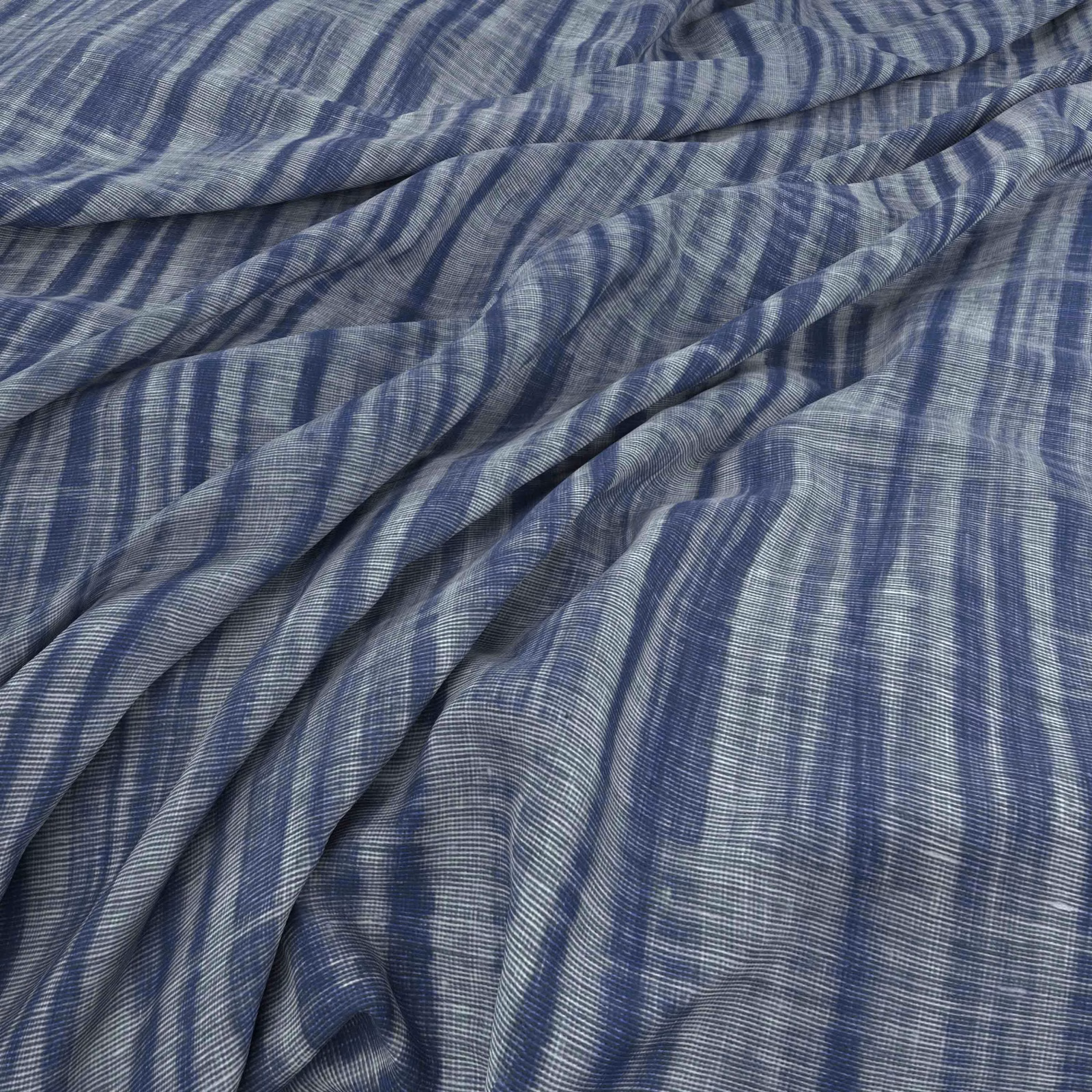Indigo blue fabric with irregular pale vertical stripes gathered into soft folds