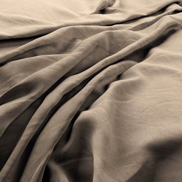 Warm flax-beige linen surface gathered into deep, softly shadowed folds