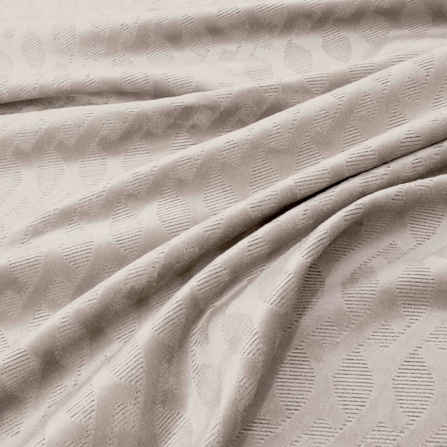 Pale oyster fabric with raised oval motifs and fine horizontal hatching in soft folds