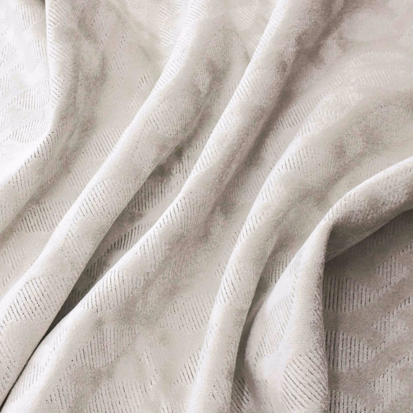 Pearl ivory fabric with subtle broken-line geometric weave in soft folded drape