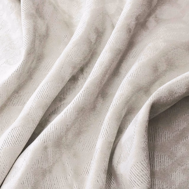 Pearl ivory fabric with subtle broken-line geometric weave in soft folded drape