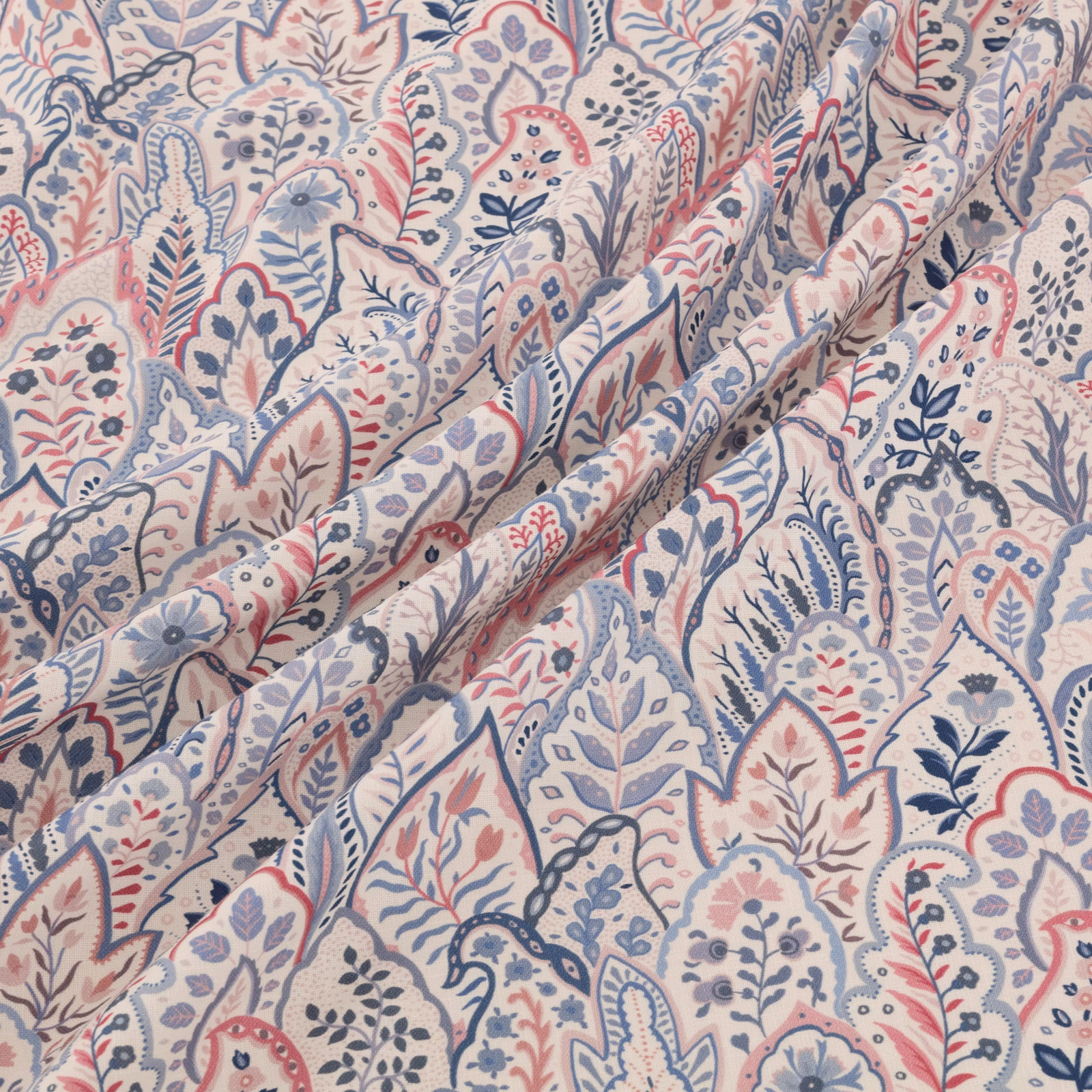 Cream paisley floral fabric with dusty blue, blush and slate motifs in soft folds