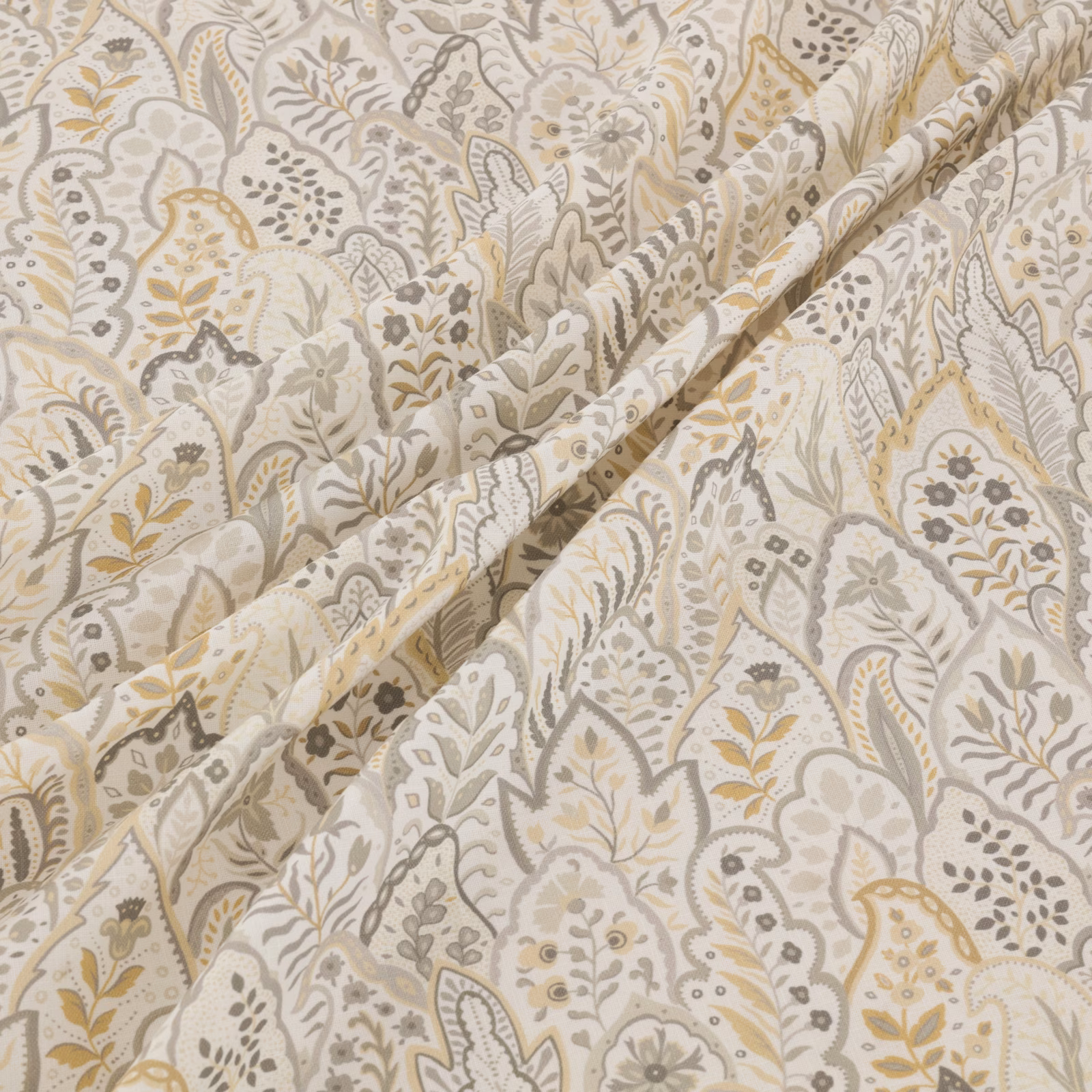 Cream Hitherhill textile with grey, taupe and ochre paisley botanicals in soft folds