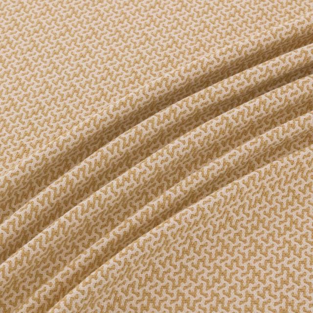 Warm sandy-tan woven textile with a cream meandering micro-pattern and folded texture