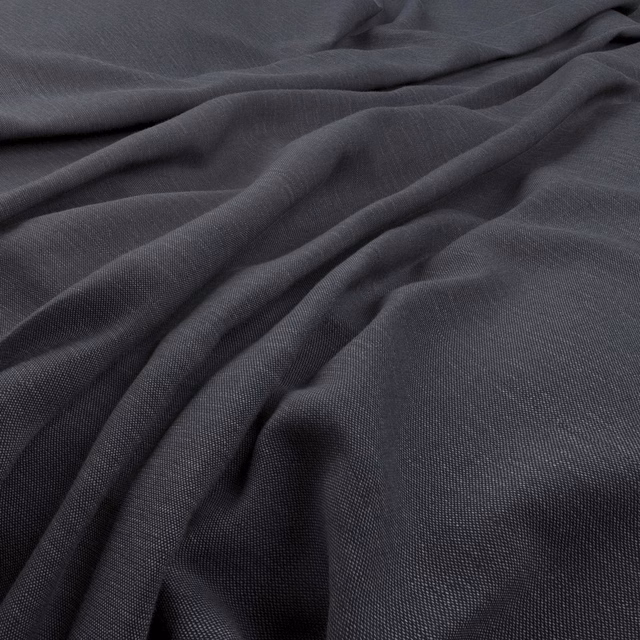 Deep charcoal indigo fabric with a fine weave falling in soft fluid folds