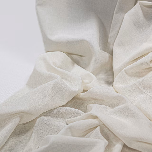 Soft ivory fabric with fine woven texture gathered into fluid folds