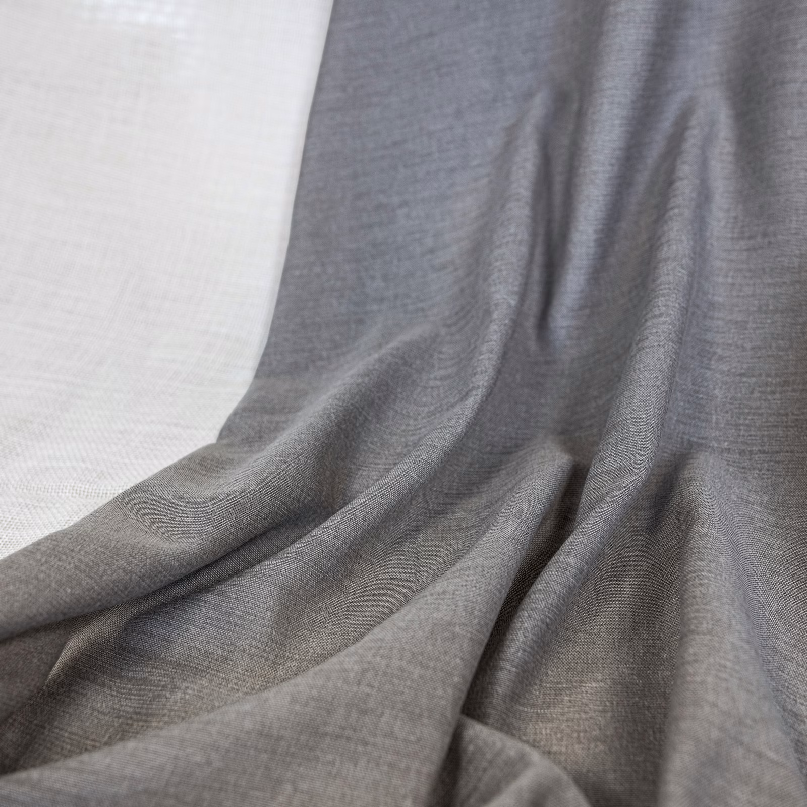 Cool mid-grey woven fabric gathered into softly rippled, fluid folds