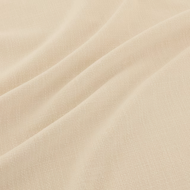 Warm ecru fabric with a fine crosshatched weave arranged in soft flowing folds