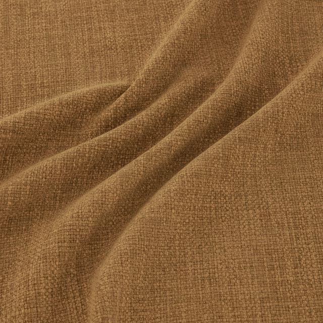 Warm nutmeg-brown woven fabric with fine tactile texture folded into soft drapes