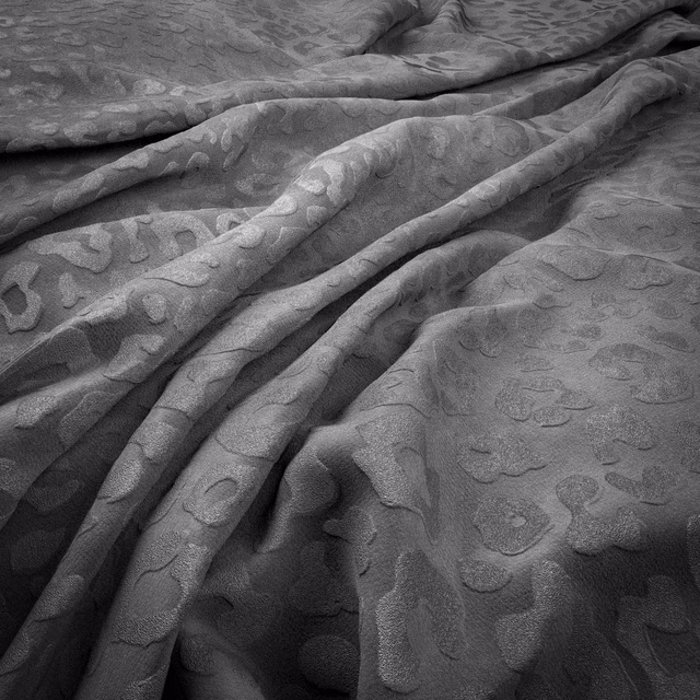Cool zinc-grey fabric with raised tonal jaguar spots and soft folds