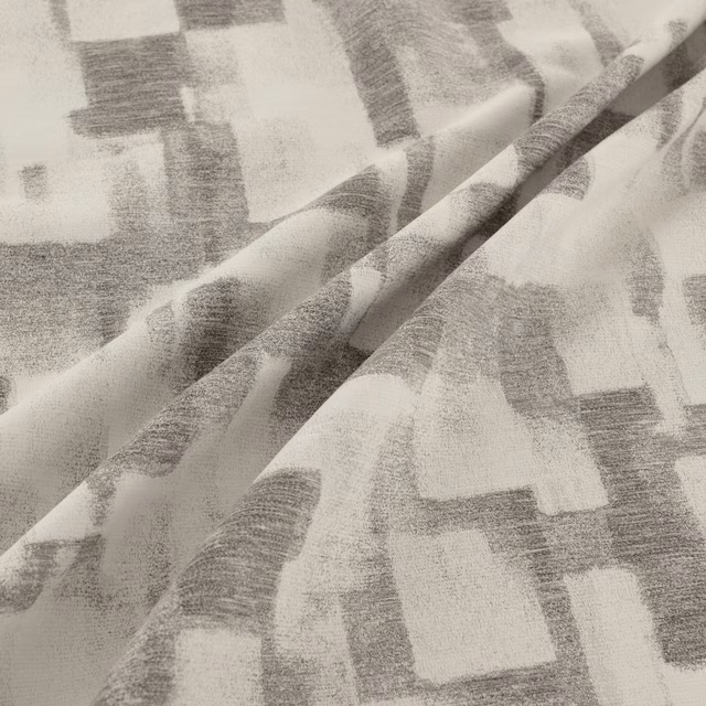 Soft magnesium-grey fabric with oversized blurred blocks and a lightly textured woven surface