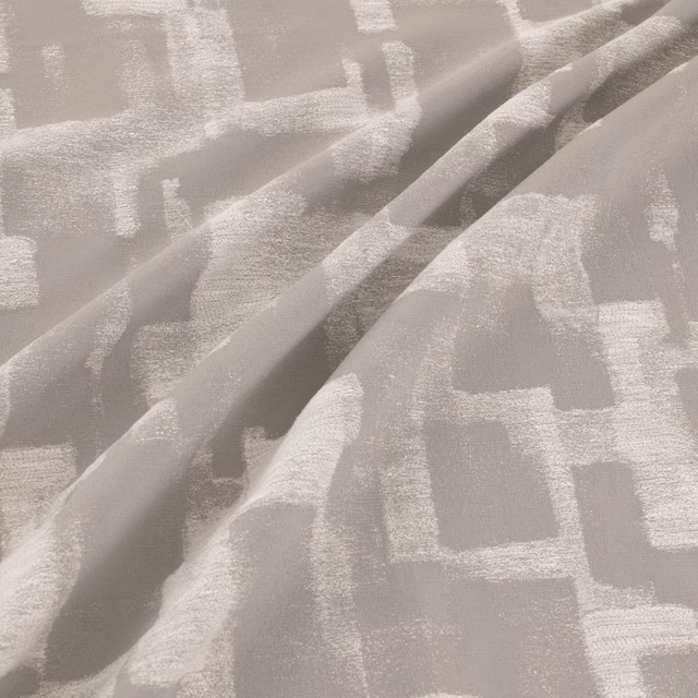 Steel-grey abstract geometric fabric with softly brushed texture folded into broad ripples